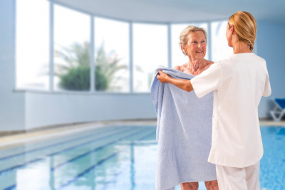 Caregiver Handing a Towel to an Elderly Woman